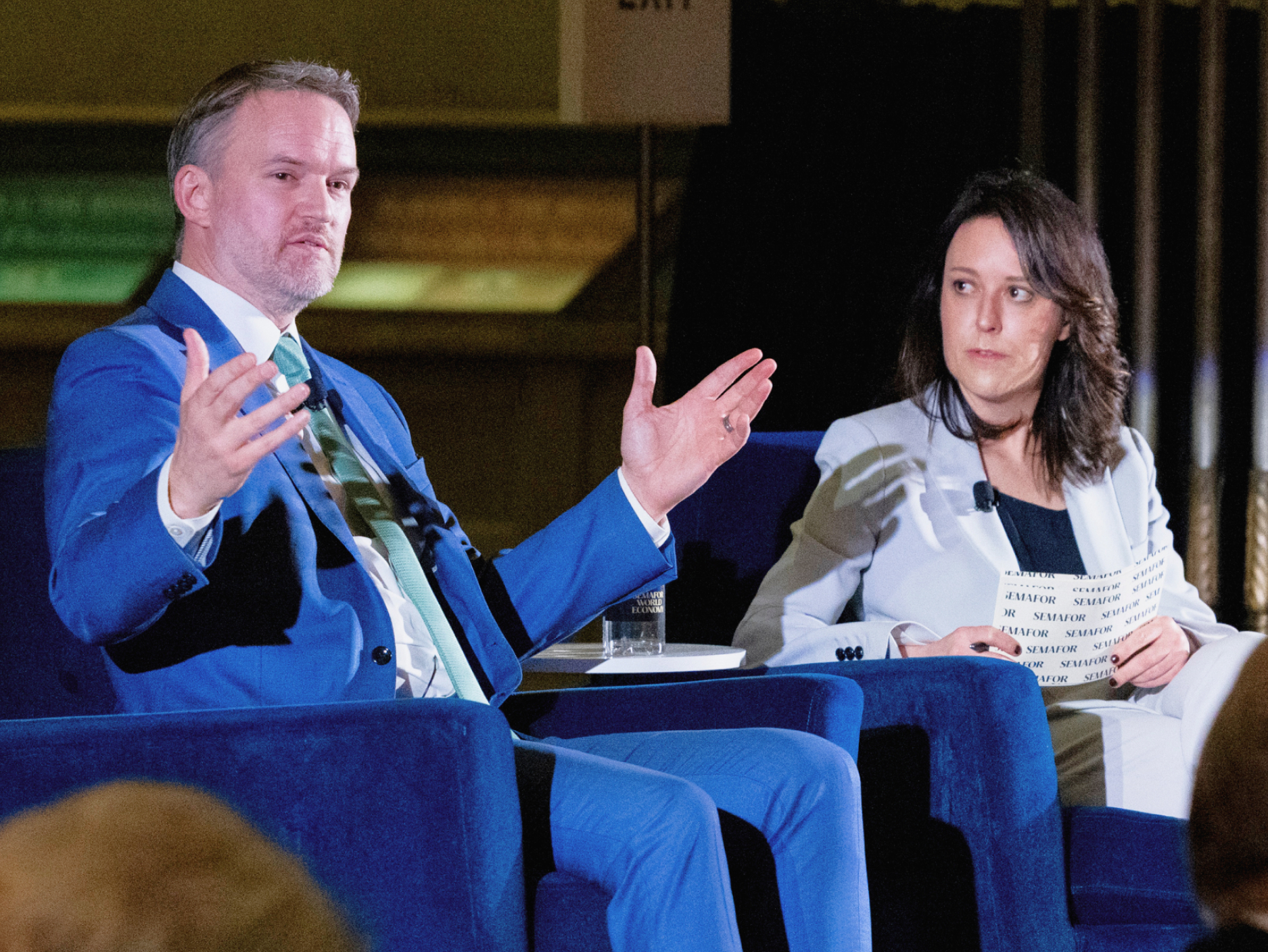 Two panelists in conversation on stage at a Semafor World Economy event.