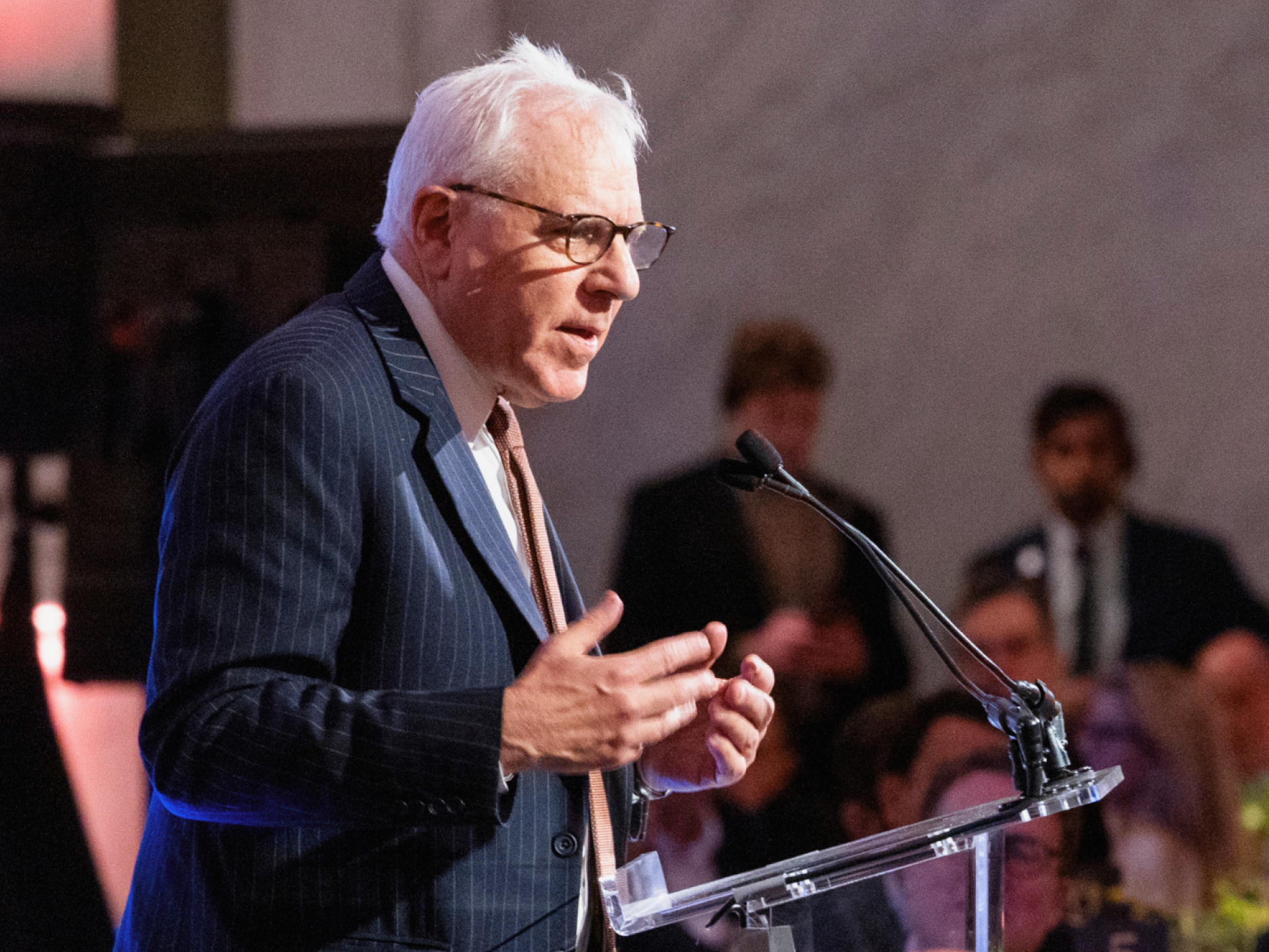 A man speaking at a podium during a conference session