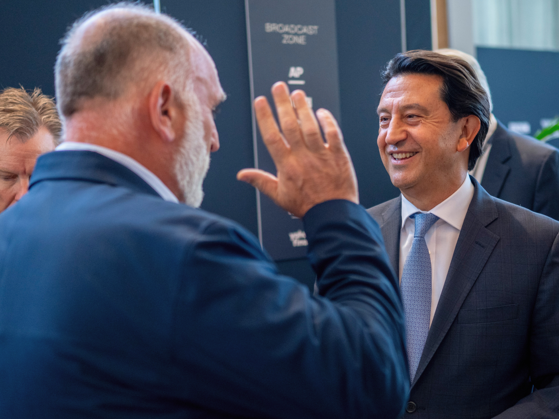 Two people talking and smiling at a Semafor World Economy event.
